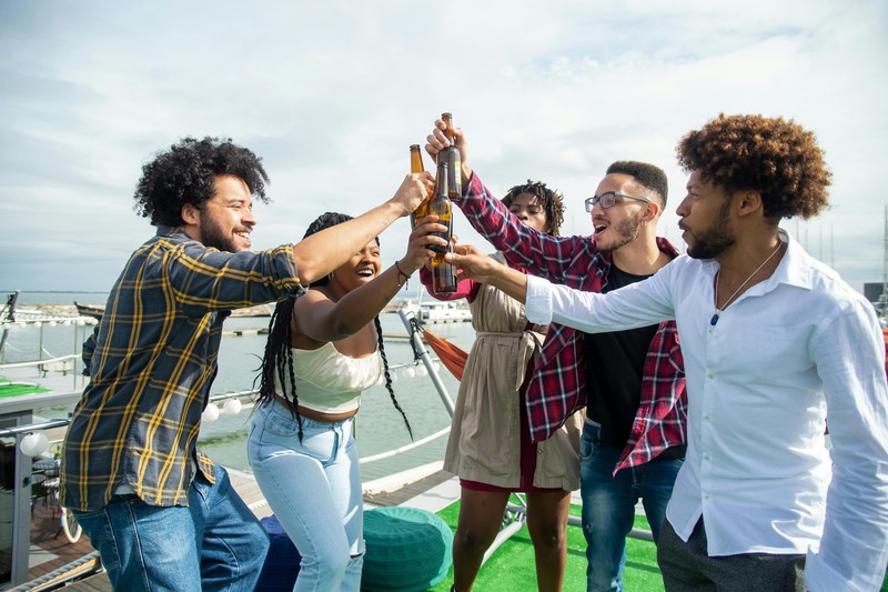 Group of men celebrating on a party boat during a daytime bachelor party