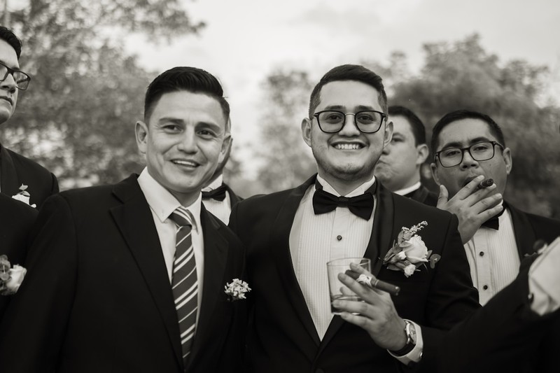 A group of groomsmen wearing custom t-shirts making a toast at a bachelor party