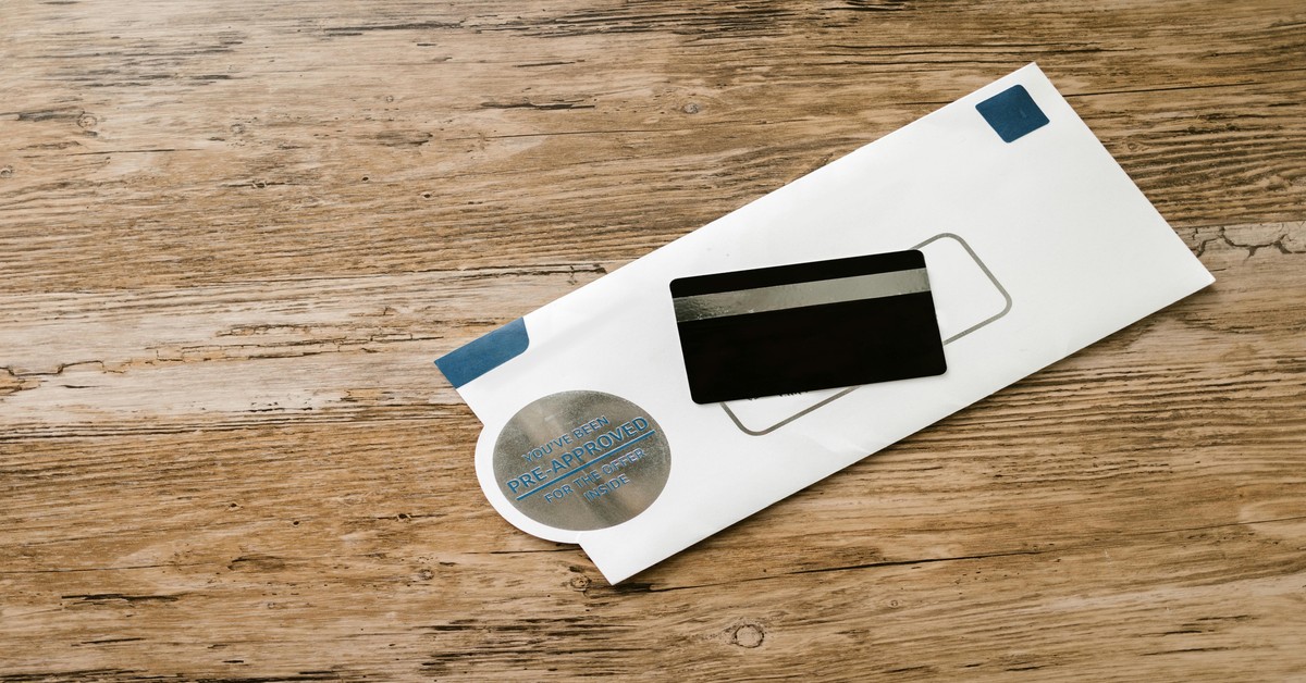 A mockup of three bachelor party invitations on a rustic wooden table with gold foil details and envelope liners.