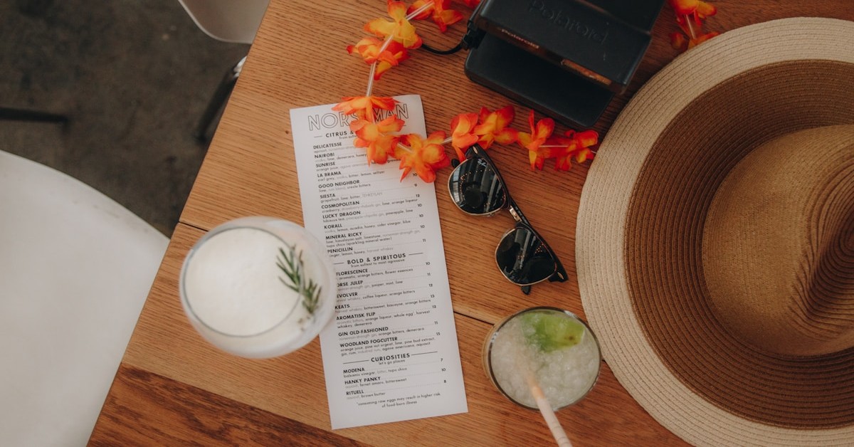 A bachelor party planning checklist on a table with drinks and sunglasses