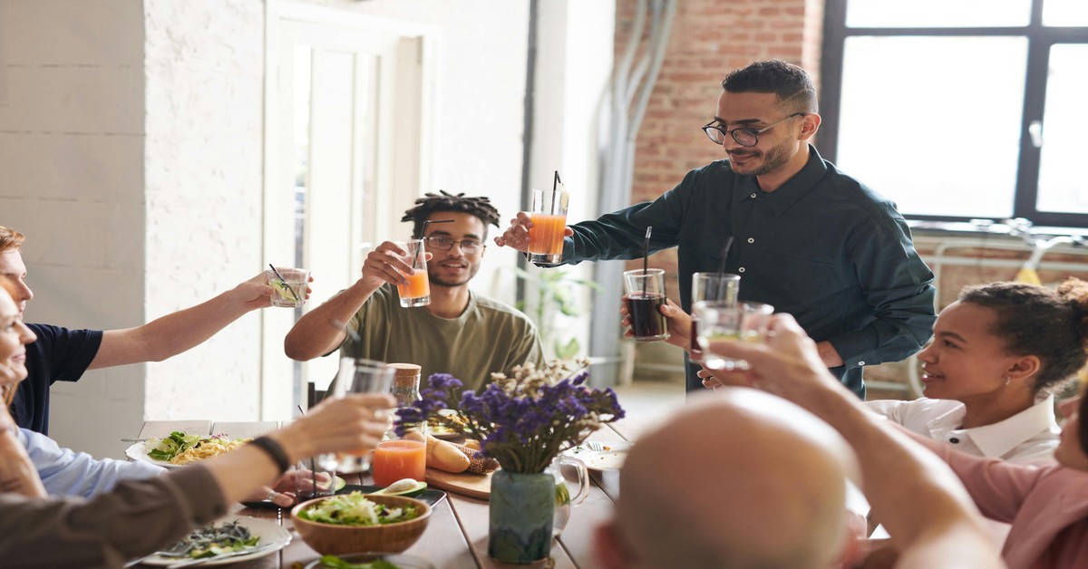 Group of men raising glasses for a toast at a bachelor party dinner