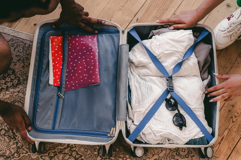 Packing cubes and travel essentials arranged on a bed for a weekend trip