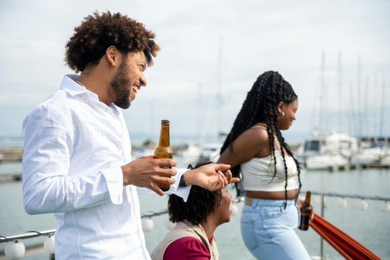 Group of friends on a catamaran party boat near Cancun with drinks and music