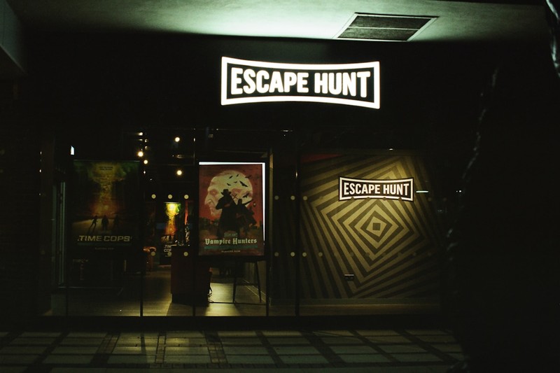 Team of players collaborating to solve a puzzle in an escape room