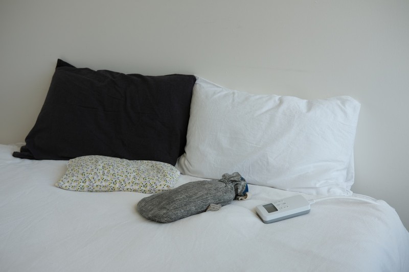 Essential Hangover Recovery Gear for Travelers travel hangover recovery kit items including a reusable water bottle, supplements, and an eye mask on a hotel bed
