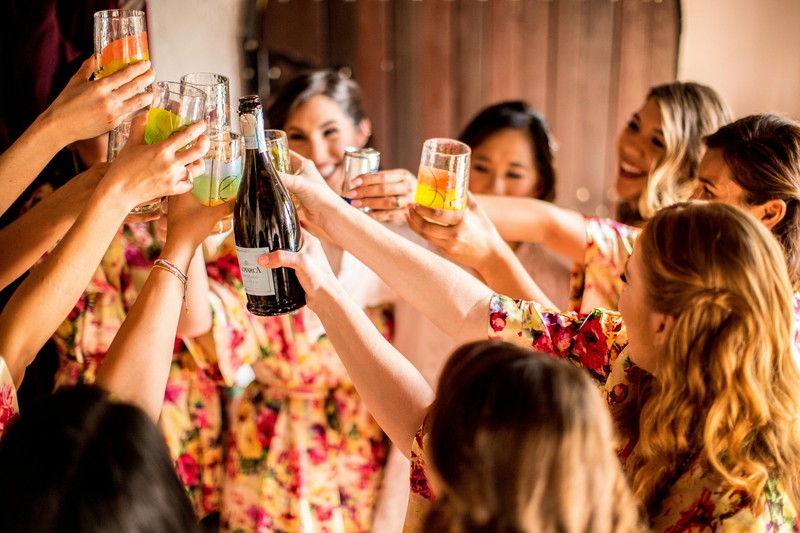 Summit Toast at a Hiking Bachelorette Party Women celebrating at a mountain summit with a toast during a bachelorette party