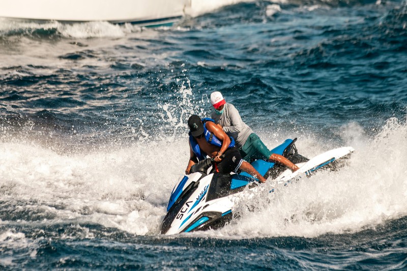 Group of men riding jet skis in the clear blue waters near Key West with the island in the background