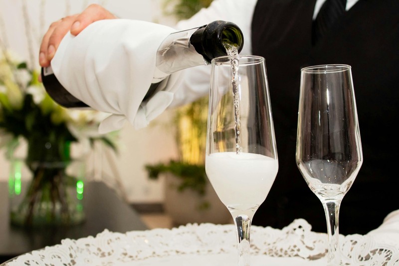 Bottle service pouring champagne at a VIP table in a nightclub