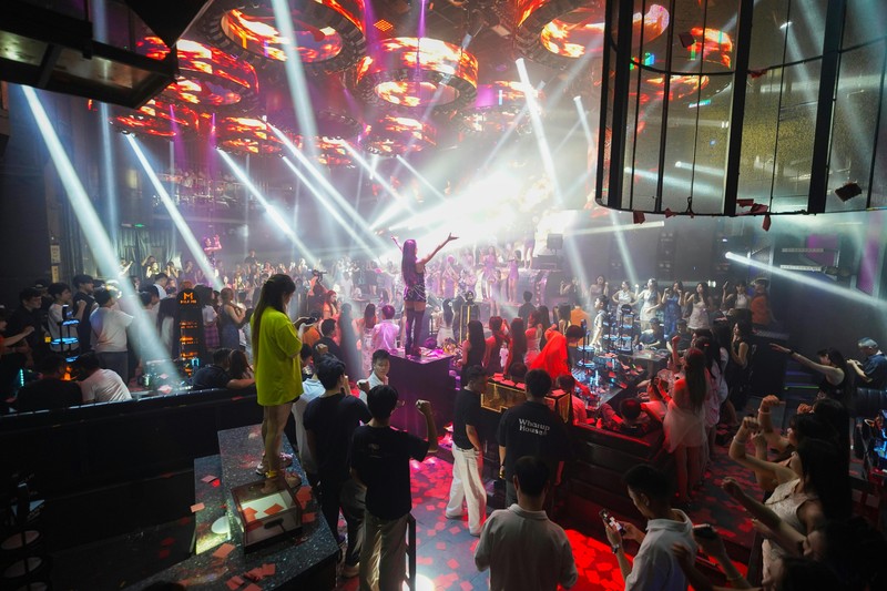 Guests at a VIP table in a nightclub dancing and enjoying the music