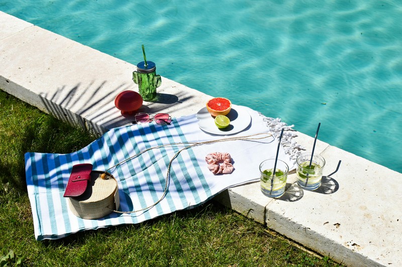 Rugged Portable Speaker for Bachelor Party A rugged portable Bluetooth speaker sitting by a pool during a daytime party