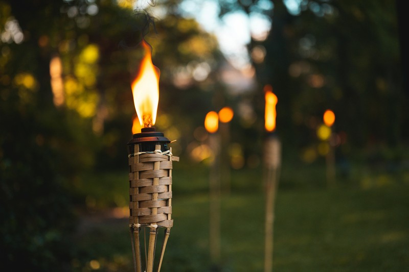 Tropical luau bachelorette party decorations with pink and gold accents, leis, and tiki torches